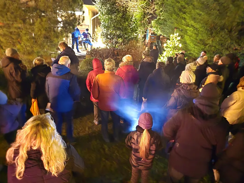 Gäste lauschen der Musik beim lebendigen Adventskalender in Adenstedt